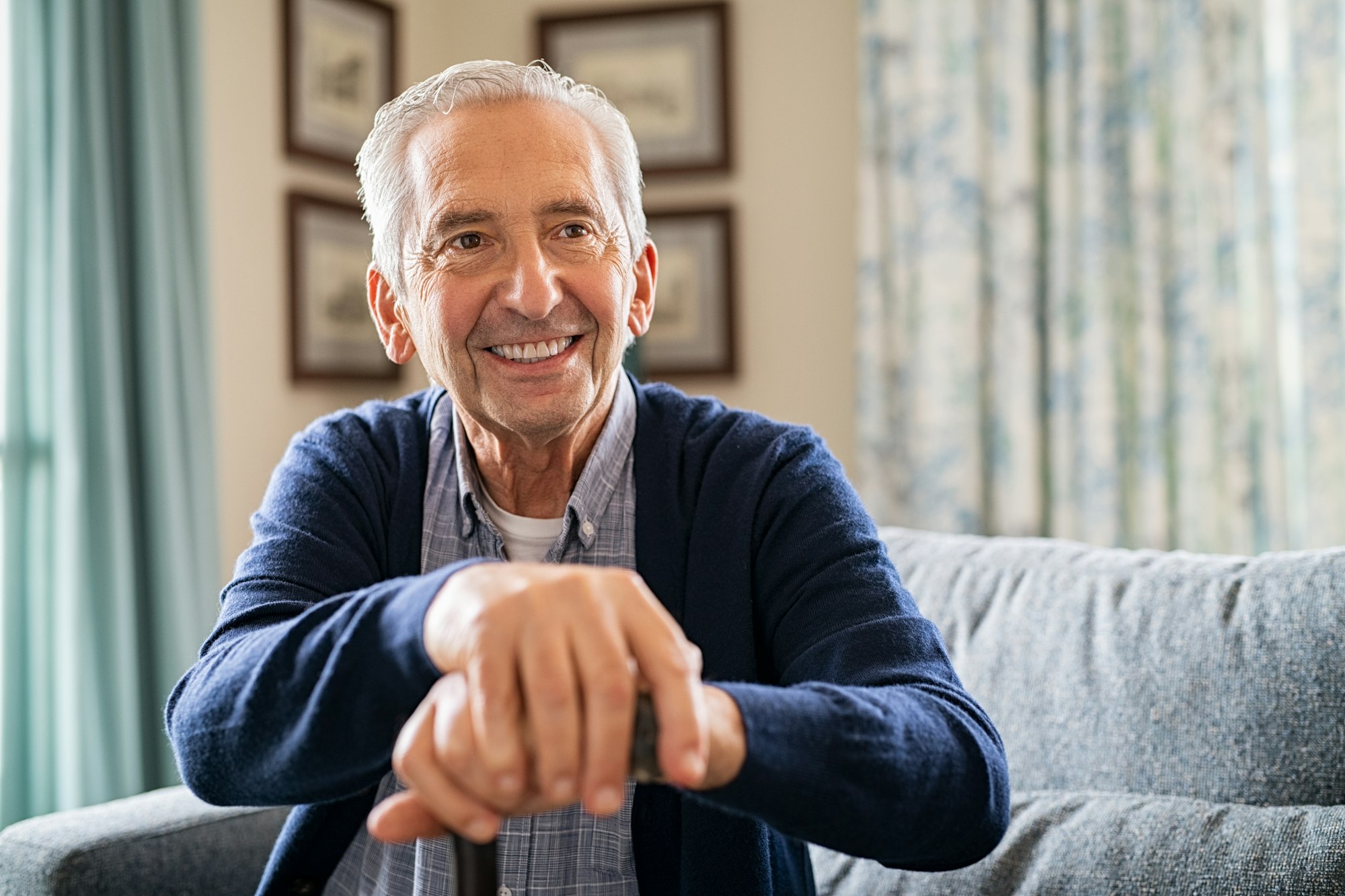 Happy old man holding walking cane